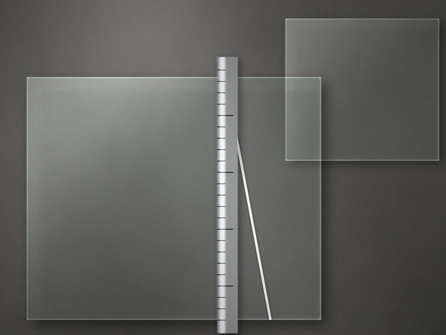 A sheet of glass on the felted cutting bench beside a steel straight-edge, a fresh score line running across it.